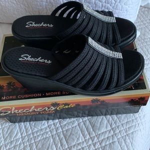 Slide on black sandals with rhinestones.